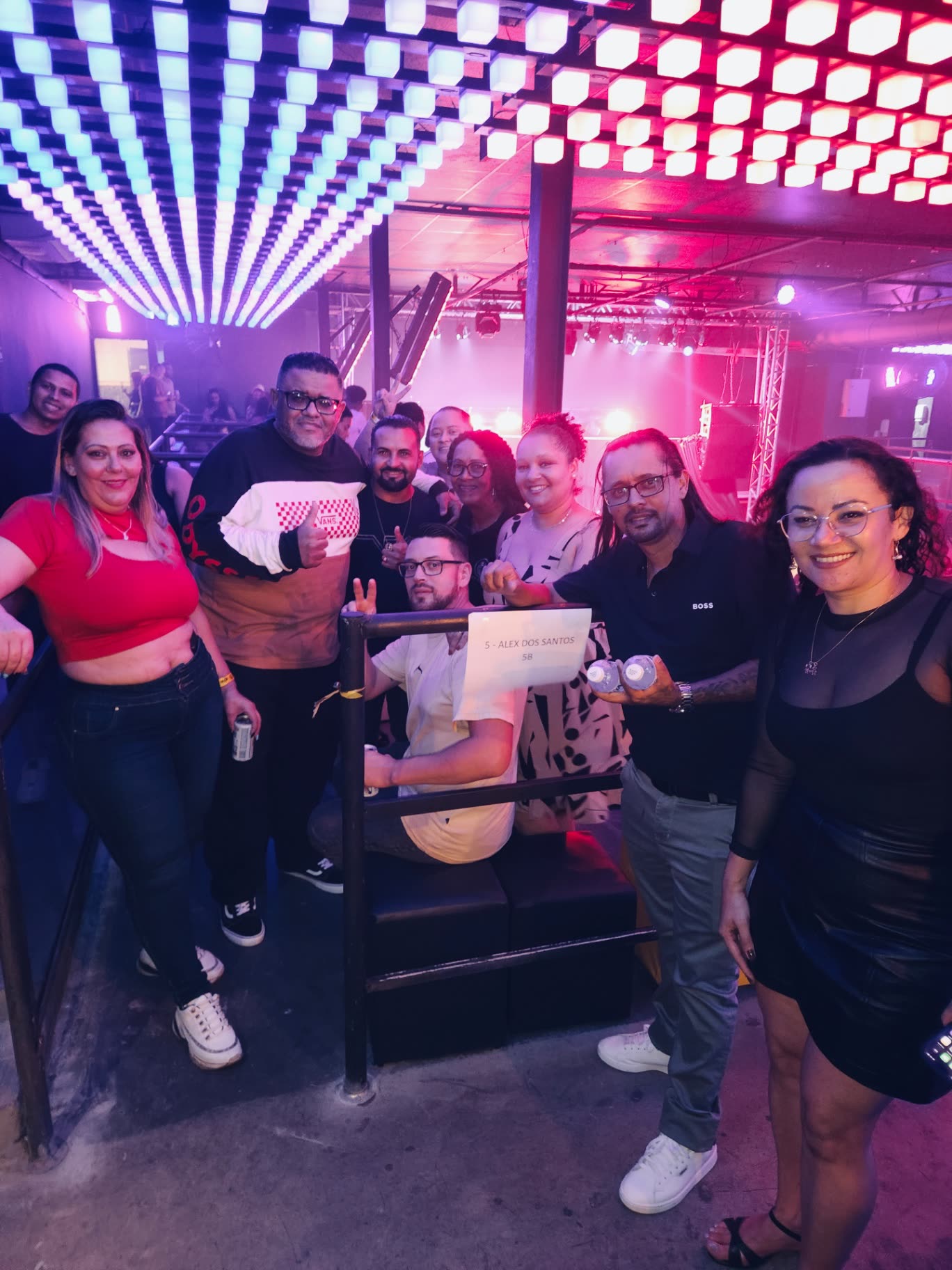 Convidados celebrando sob o painel de luzes